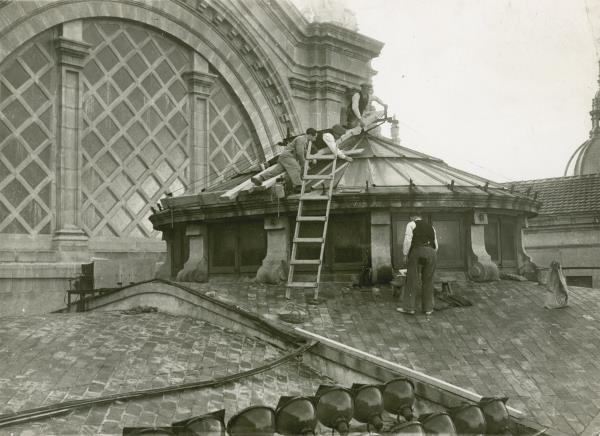Construction workers working on the roof of the Palau Nacional. 